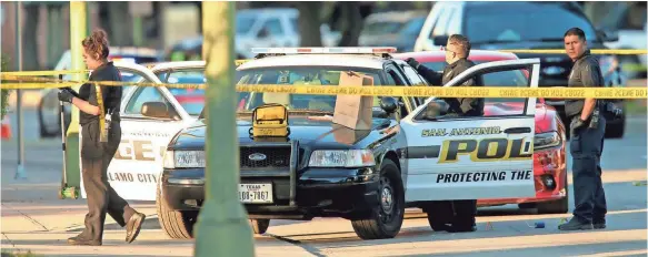  ?? EDWARD A. ORNELAS, AP ?? San Antonio Police personnel investigat­e the scene after Detective Benjamin Marconi was fatally shot on Sunday. Four officers were shot in attacks nationwide.