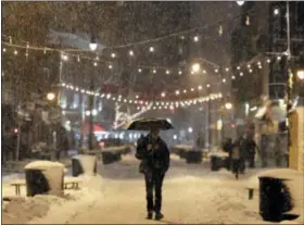  ?? JULIO CORTEZ — THE ASSOCIATED PRESS ?? A person holds an umbrella while walking in downtown Jersey City, N.J., during a snowstorm, Wednesday.