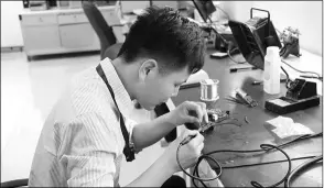  ??  ?? An engineer tests an electricit­y meter chip at a research and developmen­t lab of Shanghai Belling.