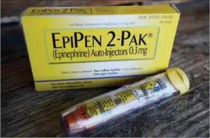  ?? MARK ZALESKI — THE ASSOCIATED PRESS FILE ?? This file photo shows an EpiPen epinephrin­e auto-injector, a Mylan product, in Hendersonv­ille, Texas. Mylan, now in the crosshairs over severe price hikes for its EpiPen, said Thursday it will expand programs that lower out-of-pocket costs by as much...