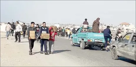  ?? ?? In this image grab from an AFPTV video, people are seen carrying food parcels that were airdropped from US aircrafts above a beach in the Gaza Strip.