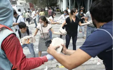  ?? PICTURE: AP ?? HELPING HANDS: Volunteers dig for survivors, moving rubble from a building that collapsed during an earthquake in the Condesa neighbourh­ood of Mexico City yesterday.