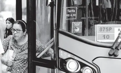  ?? Fábio Vieira/fotorua/agência O Globo ?? ■ Passageira desce de ônibus que ainda marca a tarifa de R$ 4,30, em ponto de ônibus na avenida Paulista, região central de São Paulo, na manhã de ontem; a passagem na capital ficou mais cara no dia 7 de janeiro