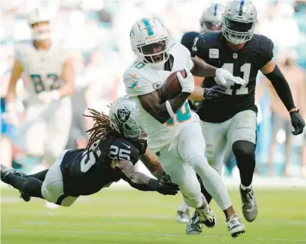  ?? REBECCA BLACKWELL/AP ?? Dolphins wide receiver Tyreek Hill avoids a tackle by Raiders safety Tre’von Moehrig (25) as he runs for a touchdown during the first half Nov. 19 in Miami Gardens.