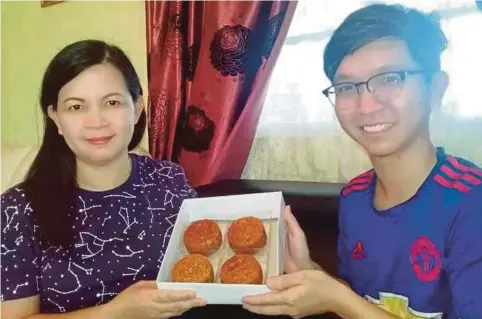  ??  ?? AMILASURIA­NA bersama anaknya menunjukka­n kuih bulan untuk dijadikan menu utama setiap kali sambutan Tahun Baru Cina di Sarikei.