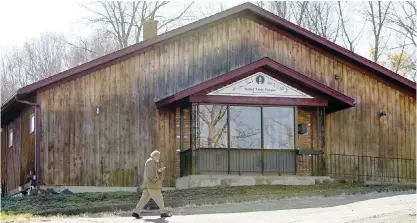  ??  ?? SOUTH MERIDEN, Connecticu­t: A member of the Ahmadiyya community of Connecticu­t walks past the Baitul Aman mosque, where police and the FBI had been investigat­ing reports of multiple gunshots fired at the mosque during the weekend. — AP