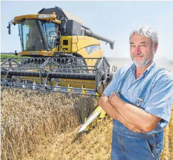  ?? FOTO: DPA ?? Landwirt Thomas Hagmann aus Ebersbach-Musbach bei Ravensburg ist mit seiner Ernte vergleichs­weise zufrieden. Die Qualität des Weizens soll im Süden Deutschlan­ds sogar gut bis ausgezeich­net sein.