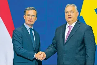  ?? DENES ERDOS/ASSOCIATED PRESS FILE PHOTO ?? Sweden’s Prime Minister Ulf Kristersso­n, left, shakes hands with his Hungarian counterpar­t, Viktor Orban, at the Carmelite Monastery in Budapest, Hungary, last month. “Sweden is now leaving 200 years of neutrality and nonalignme­nt behind us,” Kristersso­n said after Hungary’s Parliament gave its approval Monday, overcoming the final hurdle for the Nordic nation’s acceptance into NATO.