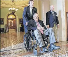  ?? [J. SCOTT APPLEWHITE/THE ASSOCIATED PRESS] ?? Republican Sen. Johnny Isakson, who is recovering from two back surgeries, is wheeled away from the Senate chambers Thursday. Isakson has been recuperati­ng in his Georgia home for that past several weeks, but he got his doctor’s permission to return to...