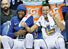  ?? AP Photo/Sue Ogrocki ?? ■ Golden State Warriors forward Kevin Durant, left, and guard Stephen Curry, right, laugh on the bench during the third quarter against the Oklahoma City Thunder on Nov. 22, 2017, in Oklahoma City.