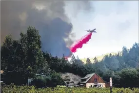  ?? NOAH BERGER — THE ASSOCIATED PRESS ?? An air tanker drops retardantw­hile battling the Glass Fire in St. Helena, Calif., on Sunday. Deaths related to recent fires in the state total 30.