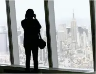  ?? — Reuters ?? A woman photograph­s the Manhattan skyline from the One World Observator­y observatio­n deck on the 100th floor of the One World Trade centre tower in New York.