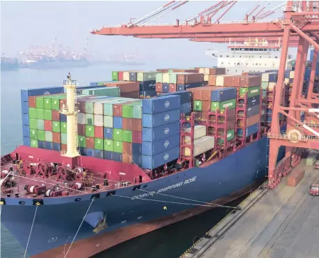  ??  ?? CONTAINERS are loaded on to a cargo ship at the port in Qingdao in east China’s Shandong province. China’s government reports 2018 exports rose 7.1 percent as a trade battle with Washington intensifie­d, while imports were up 12.9 percent. | Chinatopix via AP