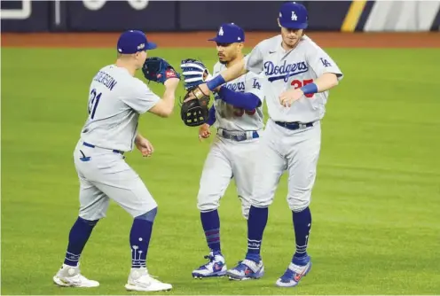  ?? (USA TODAY Sports) ?? Los Angeles Dodgers left fielder Joc Pederson (left) celebrates with right fielder Mookie Betts (centre) and centre fielder Cody Bellinger after their 7-3 win against the Atlanta Braves in game five of the 2020 NLCS at Globe Life Field in Arlington, Texas.