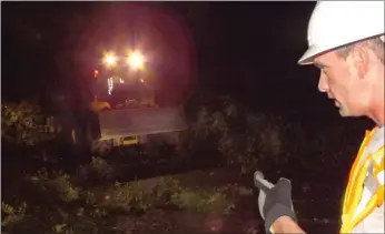  ?? Times photograph by Annette Beard ?? Street superinten­dent Nathan See ran the chainsaw Saturday night clearing a tree off Carr Street while Tom Sheets, Street Department employee, operated the U80 loader. The two put in three hours each beginning at 11 p.m. clearing city streets of trees...