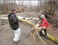  ?? Arkansas Democrat-Gazette/THOMAS METTHE ?? Sandy Wilson of Pangburn and her son, Drew, look at the damage after water from a broken pond levee rushed past her home before dawn Wednesday. Flooding continues to cause problems around the state.