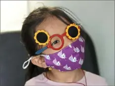  ?? Pam Panchak/Post-Gazette ?? Kritika Gurung, 6, a kindergart­en student at J.E. Harrison Education Center in the Baldwin-Whitehall School District, looks at an eye chart with special glasses during an eye exam Thursday at a Vision to Learn mobile clinic.