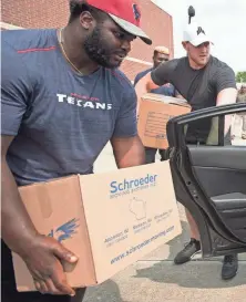  ?? POOL PHOTO BY BRETT COOMER, HOUSTON CHRONICLE ?? Texans teammates D.J. Reader, left, and J.J. Watt distribute relief supplies to people impacted by Hurricane Harvey and heard tales of heroism while doing so 3C