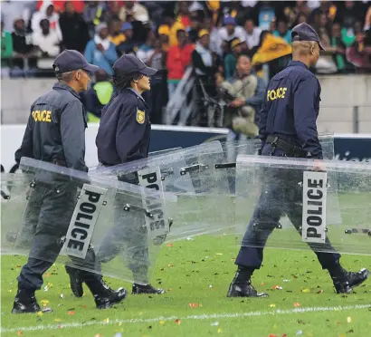  ?? Picture: Gallo Images ?? Police on the pitch at Nelson Mandela Bay Stadium on Saturday. A fan was shot dead during a pitch invasion.