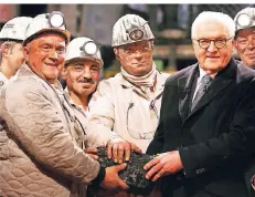  ?? FOTO: REUTERS ?? Jürgen Jakubeit (l.) und sechs weitere Kumpel überreiche­n Bundespräs­ident Frank-Walter Steinmeier das letzte Stück Kohle.