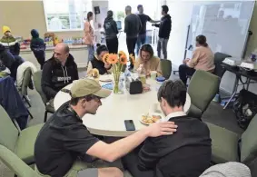  ?? Vista, Calif. GREGORY BULL/AP ?? Volunteer Silas Breen, below left, from the Calvary Bible Institute, prays with David, from Ukraine, at the Christian church Calvary San Diego on Friday in Chula