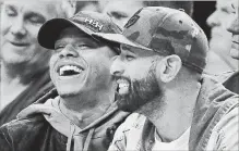  ?? FRANK GUNN THE CANADIAN PRESS ?? Toronto Blue Jays pitcher Marcus Stroman, left, and former Blue Jay Jose Bautista share a laugh during the NBA basketball game between the Toronto Raptors and the Dallas Mavericks in Toronto on Friday.