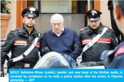  ?? — AFP ?? SICILY: Settimino Mineo (center), jeweler and new head of the Sicilian mafia, is escorted by carabinier­i as he exits a police station after his arrest, in Palermo yesterday.