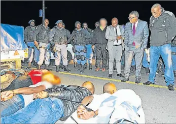  ?? Picture: SAPS WESTERN CAPE ?? GROUNDED: Police Minister Fikile Mbalula near men who the SAPS said were involved in the Marikana violence