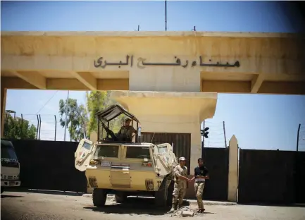  ??  ?? EGYPTIAN SOLDIERS stand guard in front of the Rafah border crossing between Egypt and the southern Gaza Strip.