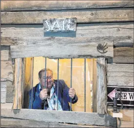  ?? ?? Samsville Gallery owner Sam Abweh poses in the “jail” in his Westernsou­thwestern gift shop exhibition at The Cowboy Channel Cowboy Christmas. His business, out of Santa Fe, N.M., has had a booth at Cowboy Christmas for decades.