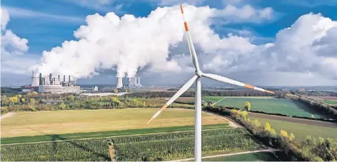  ?? FOTO: ANDREAS ENDERMANN ?? Neue und alte Energiewel­t dicht beieinande­r: ein Windrad in unmittelba­rer Nachbarsch­aft zum RWE-Kraftwerk Grevenbroi­ch-Neurath.