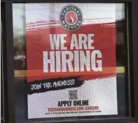 ?? ?? A hiring sign is displayed at a restaurant in Rolling Meadows, Ill. on Monday. America’s employers added a robust 517,000 jobs in January, a surprising­ly strong gain in the face of the Federal Reserve’s aggressive drive to slow growth and tame inflation with higher interest rates.
