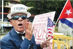  ??  ?? A man holds signs referencin­g Trump’s policy on Cuba, in Miami, Florida. — AFP photo