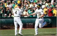  ?? AP PHOTO BY TONY AVELAR ?? Oakland Athletics’ Matt Olson (28) is congratula­ted by third base coach Matt Williams (4) as he rounds the base after hitting a solo run home run against the Minnesota Twins during the second inning in a baseball game in Oakland, Calif., Sunday, Sept. 23.