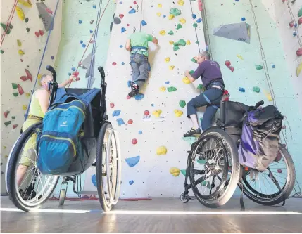  ??  ?? Auch aus dem Rollstuhl heraus hoch hinauf: Der rechte Kletterer ist MS-Patient und trainiert hier beim Alpenverei­n in Karlsruhe.