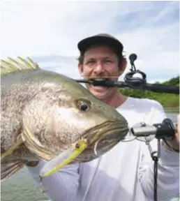  ??  ?? Home ground ... a crocodile keeps a wary eye on the anglers (top); Jackson Atkins with his first Papuan black bass (above). It was released to fight another day, shortly after the photo was taken.