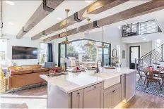  ??  ?? The main living areas are unusually open to each other. From the kitchen island, communicat­ion between household members in the living, dining, and outdoor patio is easy. The large outdoor patio, below, provides ample space for family dining and...