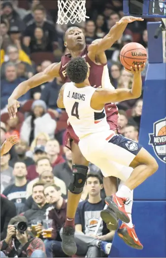  ?? Bill Kostroun / Associated Press ?? UConn’s Jalen Adams (4) attempts a shot as Florida State forward Mfiondu Kabengele defends on Saturday.