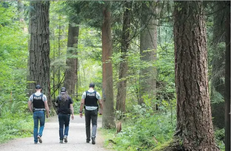  ?? JASON PAYNE/POSTMEDIA NEWS/FILES ?? Police walk through Central Park in Burnaby on July 21 near the spot where Marrisa Shen was found dead.