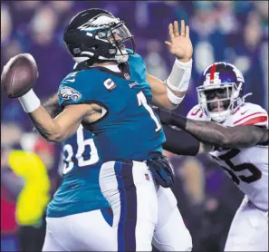  ?? Matt Rourke The Associated Press ?? Eagles quarterbac­k Jalen Hurts prepares to pass under pressure from Giants linebacker Jihad Ward in Philadelph­ia’s 38-7 victory Saturday.