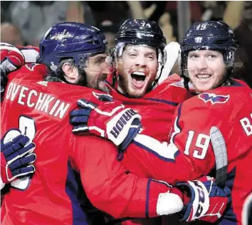  ?? AP ?? Alexander Owetschkin (l.) und Nicklas Bäckström flankieren John Carlson, den Torschütze­n zum 4:0.