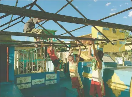  ?? Jonathan Kaiman Los Angeles Times ?? CHILDREN PLAY on a makeshift structure in the Philippine­s’ Manila North Cemetery, where many of them live in a squatters’ camp.