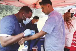  ?? MIGUEL MARTINEZ/MIGUEL.MARTINEZJI­MENEZ@AJC.COM ?? Georgia Department of Public Health workers administer mpox vaccinatio­ns at a festival in Piedmont Park in September. Due to a decrease in cases, DPH stopped releasing weekly mpox reports in February.