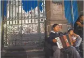  ??  ?? A man plays the accordion outside the Cathedral at Zocalo.