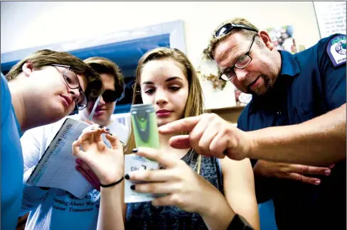  ?? NEWS-SENTINEL FILE PHOTOGRAPH ?? Storm Drain Detectives Dylan O'Ryan, Kyle O'Ryan and Haley Hower calibrate the pH meter as they get ready to test the water in the Mokelumne River with the help of Brian Bock, an environmen­tal compliance inspector with the City of Lodi.