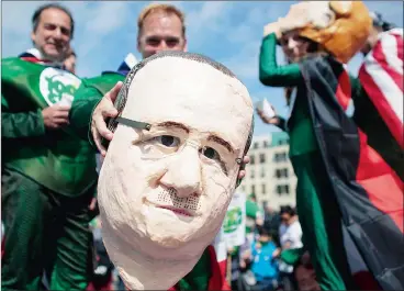  ?? Picture: AP ?? FACE-OFF: A demonstrat­or shows a mask depicting French President Francois Hollande during a protest in Berlin yesterday. German Chancellor Angela Merkel and Hollande attended the internatio­nal meeting on climate protection in preparatio­n for the UN...