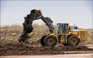  ?? PHOTOS BY JAY JANNER / AMERICAN-STATESMAN ?? A worker dumps unscreened compost, a mixture of biosolids and yard waste, at the Hornsby Bend wastewater treatment plant in June. City staffers have estimated that more than 60,000 cubic yards of the compost is sitting on the site, with some of it...