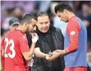  ?? — AFP ?? Tunisia head coach Nabil Maaloul (centre) distribute­s dates to players Naim Sliti (left) and Rami Bedoui at a friendly in Geneva on June 1.