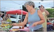  ?? Jeremy stewart ?? Judy Barber puts out vegetables at her farm’s booth at the Rockmart Farmers Market on June 23, 2022. Judy and her husband, Mike Barber, own Yorkville Hops and Produce near Rockmart.