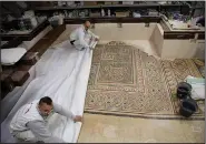  ?? AP/MAJDI MOHAMMED ?? Restoratio­n experts work on a mosaic last week inside the Church of the Nativity.